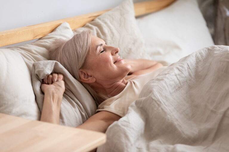 happy woman settling down to rest in bed