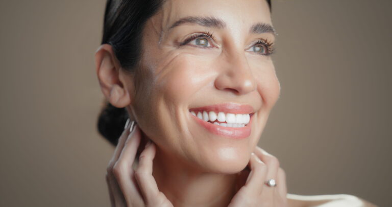 closeup photo of a woman beaming and with glowing skin