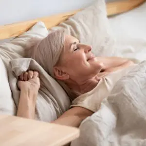 happy woman settling down to rest in bed